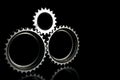 Gray connected gears closeup over black background