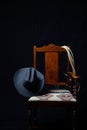 Gray cowboy hat, cattle rope and a chair with a black background Royalty Free Stock Photo