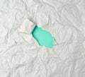 gray crumpled sheet of paper with a hole, green backing Royalty Free Stock Photo