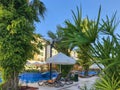 Gray deck chairs with an orange cushion by the pool with white umbrellas from the sun Royalty Free Stock Photo