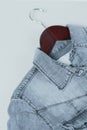 Gray denim shirt on hanger on white background. Second hand clothing shop