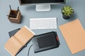 The gray desk with laptop, notepad with blank sheet, pot of flower, stylus and tablet for retouching Royalty Free Stock Photo