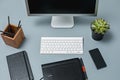 The gray desk with laptop, notepad with blank sheet, pot of flower, stylus and tablet for retouching Royalty Free Stock Photo