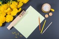 Gray desk surface with sheet of paper, color pencils, wooden pen