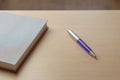Gray diary, blue pen and glasses on a brown table, selective focus. Office desk table concept Royalty Free Stock Photo