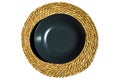 Gray dinner plate on a round woven wicker made of water hyacinth fibers, wicker table mats, rattan round woven mat Royalty Free Stock Photo