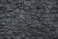 Gray dirty stone wall. Texture of grey granite. Dark rough rocks background. Weathered dark gray grunge building`s facade. Stone s Royalty Free Stock Photo