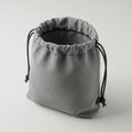 Gray drawstring bag made of fabric, standing upright on a plain surface. The texture Royalty Free Stock Photo