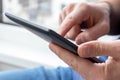 Gray e-reader electronic book in male hands. A man in with a tablet against a blurred background