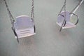 Gray empty teeter on asphalt background, swing made of wood and metal chains. Lonely and abandoned Royalty Free Stock Photo