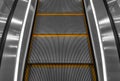 Gray escalator steps with orange lines close-up.