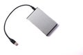 Gray external hard disk with black USB cable on white background Royalty Free Stock Photo