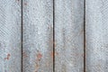 Gray fence boards with cracked paint close-up.