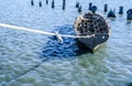 Gray fishing boat tied with a rope in blue-green water Royalty Free Stock Photo