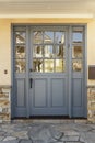 Gray front door to a home with shale porch