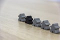 Gray gaming pieces and a black meeple, diversity concept