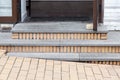 Gray granite steps of a brick threshold at the open entrance door.