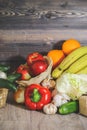 On a gray graphite wooden background, tomatoes in a box, cucumber, garlic, large red peppers, bananas, oranges, red apples in a Royalty Free Stock Photo