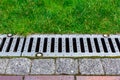 Gray grating of the drainage system for drainage of rainwater in the park. Royalty Free Stock Photo