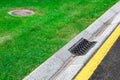Gray gutter of a stormwater drainage system on the side of asphalt road. Royalty Free Stock Photo