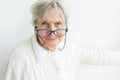 Gray hair senior lady in glasses on white wall background Royalty Free Stock Photo