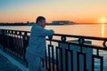 gray-haired elderly man admires the sunset on the bank of the river. The loneliness of the elderly. Craving and love for Royalty Free Stock Photo