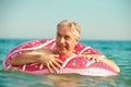 Gray-haired funny man swims on an inflatable circle in the sea Royalty Free Stock Photo