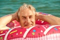 Gray-haired funny man swims on inflatable circle in the sea