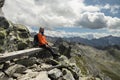 Gray-haired man with backpack reached the top, sitting on a bench and enjoying a beautiful view, Austria Royalty Free Stock Photo