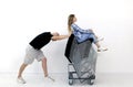 a gray-haired man pushes a stack metal chairs on which a young woman is sitting. Royalty Free Stock Photo