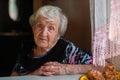 Gray-haired old lady portrait at the kitchen table Royalty Free Stock Photo