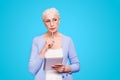 Gray haired old serious business woman wearing glasses, thinking about plans strategy future, holding paper note book Royalty Free Stock Photo