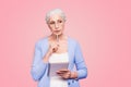 Gray haired old serious business woman wearing glasses, thinking about plans strategy future, holding paper note book Royalty Free Stock Photo