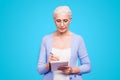 Gray haired old serious business woman wearing glasses, writing plans strategy in paper note book with pen. Isolated Royalty Free Stock Photo