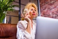 gray-haired peaceful beautiful woman sleeping on comfortable couch at home breathing fresh air, meditating with closed Royalty Free Stock Photo