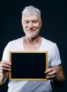 Gray haired senior man with board in his hands. Sport and health care concept