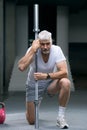 Gray haired senior man looking at sport watch at his hand. Sport and health care concept