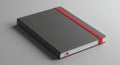 A gray hardcover notebook features a sleek design with a bright red elastic band Royalty Free Stock Photo