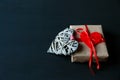 Gray heart and gift box on black wooden table. Valentines, spring background. Mock up with copyspace. happy mothers day, romantic Royalty Free Stock Photo