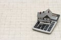 A gray house and calculator on stone background Royalty Free Stock Photo