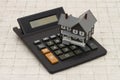 A gray house and calculator on stone background Royalty Free Stock Photo