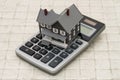 A gray house and calculator on stone background Royalty Free Stock Photo