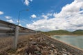 The gray iron barrier on the side of reservoir with mountain and beautiful clouds with green water and street lamps