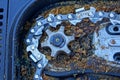 Gray iron gear and chain in dirty sawdust in an electric saw