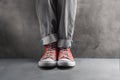 Gray jeans with nice sneakers on concrete background Royalty Free Stock Photo