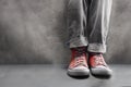 Gray jeans with nice sneakers on concrete background Royalty Free Stock Photo