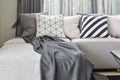 Gray L shape sofa with varies pattern and white pillows in Royalty Free Stock Photo