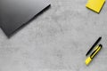 Gray laptop  yellow stickers  black pen on concrete background. Royalty Free Stock Photo