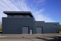 Gray large industrial building exterior warehouse grey hangar exterior with rolling gates in blue sky Royalty Free Stock Photo