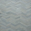 Gray marble tiles arranged in a herringbone pattern create a textured surface. Each tile Royalty Free Stock Photo